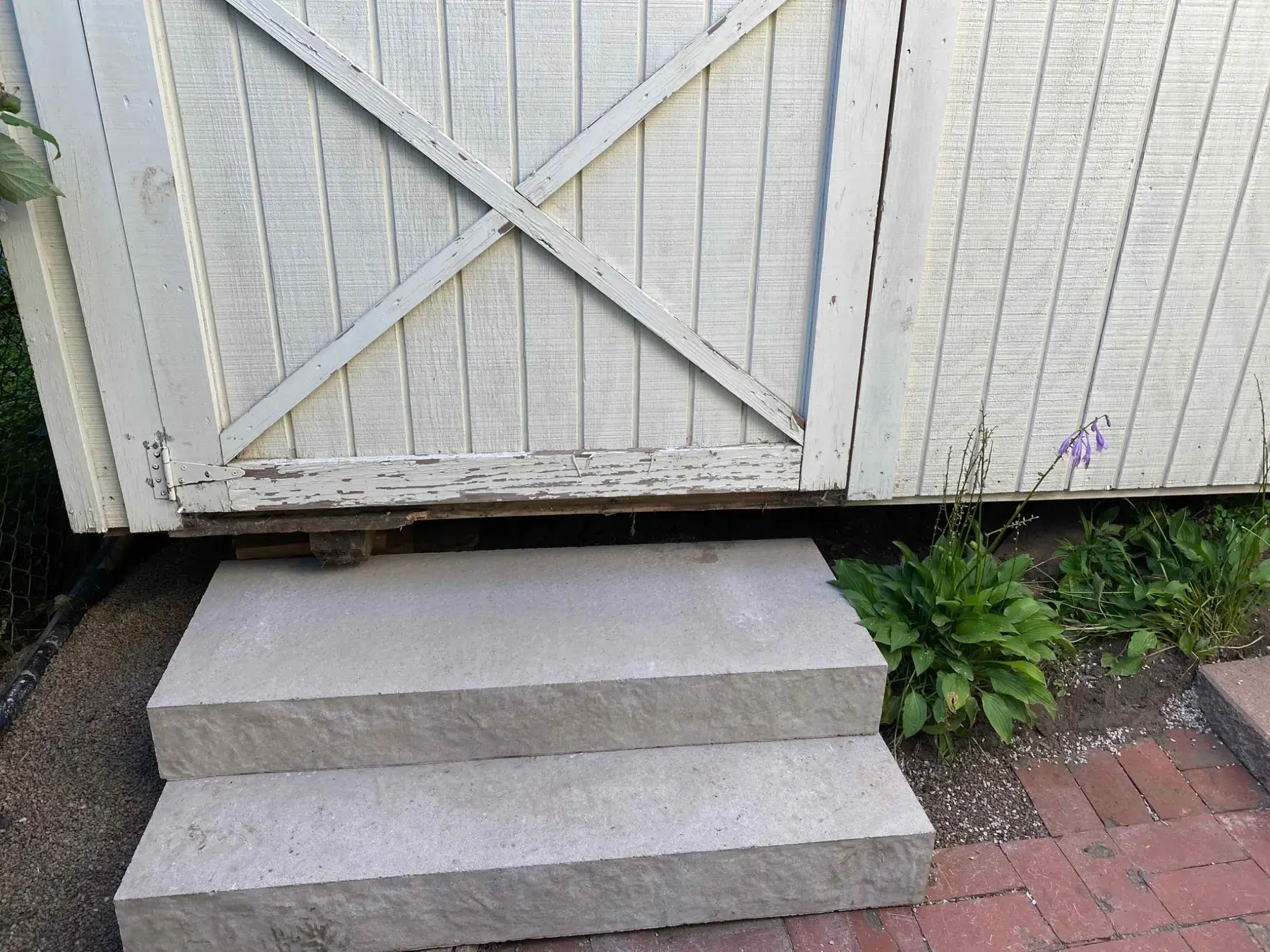 Landscaping and steps near a garden shed completed by Minnlawn